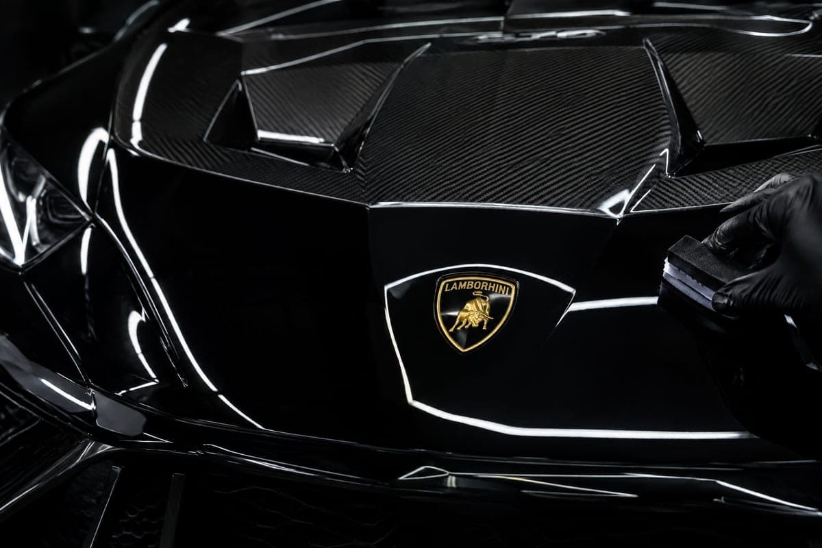 Freshly ceramic-coated black Lamborghini paint reflecting studio light